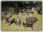 Large Stone Fire Pit Along Stream Surrounded By Furniture & Solar Lights